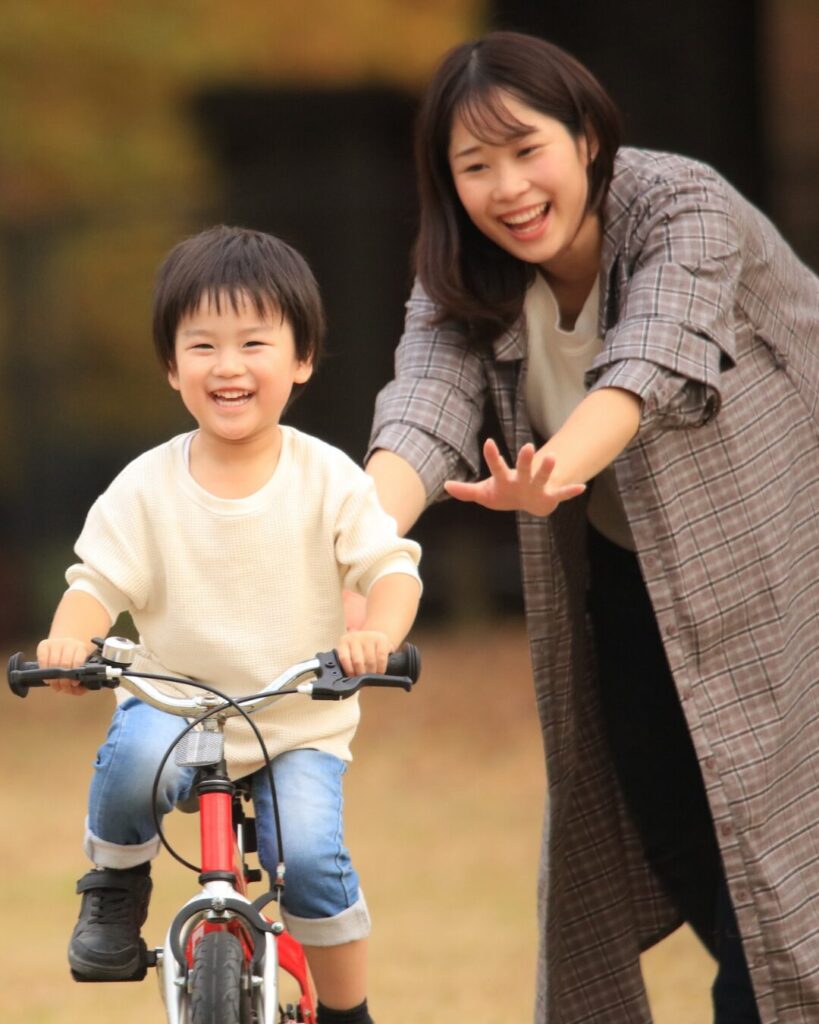 行楽シーズンで公園で遊ぶ親子